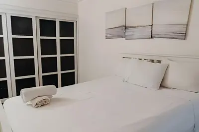 a white bed with a towel on top of it at Oceanfront 3 Bedroom With Jacuzzi and Pool in Santo Domingo