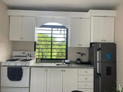 a kitchen with white cabinets and a sink and a refrigerator at Apartamento Piro 1 - 4 pax - a 5 Min De La Playa in Las Galeras