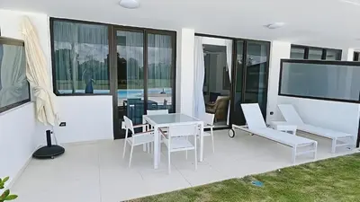 a patio with a table and chairs and a tv at Cana Rock Star-Two apartments very close-Ground floor direct access to the pool in Punta Cana
