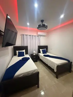 a bedroom with two beds and a flat screen tv at villa green paradise in San Felipe de Puerto Plata