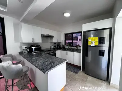 a kitchen with white cabinets and a stainless steel refrigerator at villa green paradise in San Felipe de Puerto Plata