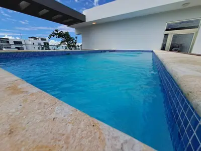 a swimming pool in front of a house at Goistay Elegant Refugio Caribeo 1br Gym Pool Naco in Santo Domingo