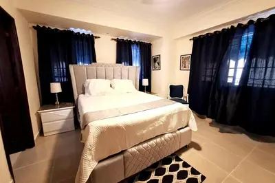 a bedroom with a large bed with black curtains at Goistay Descubre el Encanto nico de Repblica Dominicana Bella Vista in Los Prados