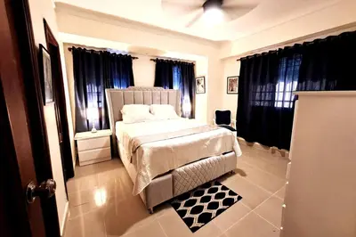 a bedroom with a white bed and black curtains at Goistay Descubre el Encanto nico de Repblica Dominicana Bella Vista in Los Prados
