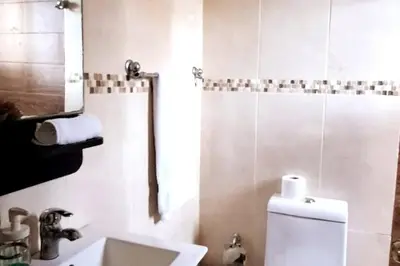 a bathroom with a toilet and a sink and a mirror at Goistay Descubre el Encanto nico de Repblica Dominicana Bella Vista in Los Prados