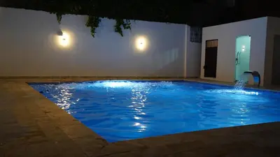 a large blue swimming pool with a water fountain at Villa Sol Taino, Hotel en Boca chica, 5 minutos del Aeropuerto Internacional las Américas in La Golondrina