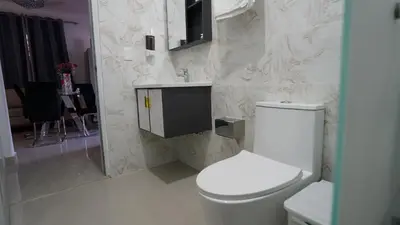 a white bathroom with a toilet and a sink at Villa Sol Taino, Hotel en Boca chica, 5 minutos del Aeropuerto Internacional las Américas in La Golondrina