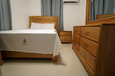 a bedroom with a wooden bed and a dresser at Villa Sol Taino, Hotel en Boca chica, 5 minutos del Aeropuerto Internacional las Américas in La Golondrina