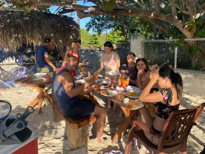 a group of people sitting at a table on the beach at Rustic House 2 in Punta Rucia
