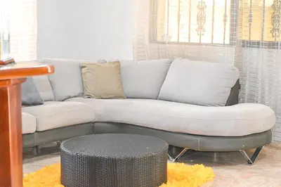 a couch sitting in a living room next to a table at Villa lujosa con piscina bayaguana in Bayaguana