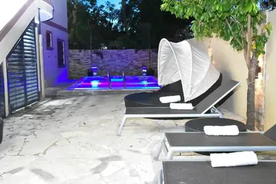 a patio with two lounge chairs and a pool at Villa lujosa con piscina bayaguana in Bayaguana