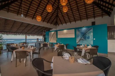 a dining room with tables and chairs and the ocean at Velero Beach Resort in Cabarete