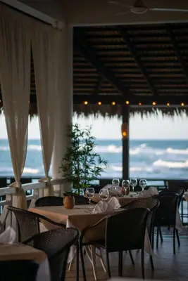a dining room with tables and chairs with a view of the ocean at Velero Beach Resort in Cabarete