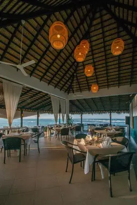 a restaurant with tables and chairs and a view of the ocean at Velero Beach Resort in Cabarete