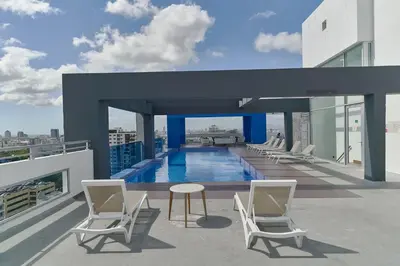 a balcony with chairs and a pool on a building at S802 Lujoso Apartamento Downtown Santo Domingo RD in Santo Domingo