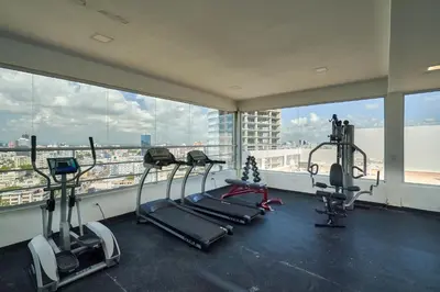 a gym with several tread machines in a room with windows at S802 Lujoso Apartamento Downtown Santo Domingo RD in Santo Domingo