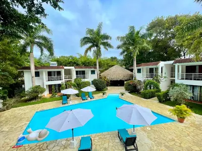 a resort with a swimming pool and umbrellas at Coral Blanco Hotel in Sosúa