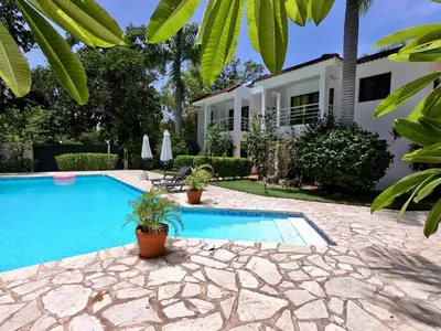 a swimming pool in front of a house at Coral Blanco Hotel in Sosúa