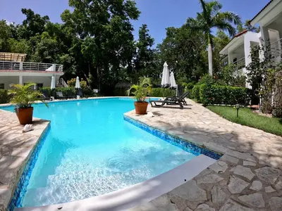 a swimming pool with blue water in a yard at Coral Blanco Hotel in Sosúa