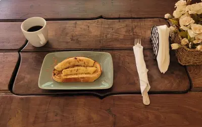 a plate with a sandwich on a table with a cup of coffee at Heritage Residences Signature Collection in Santo Domingo