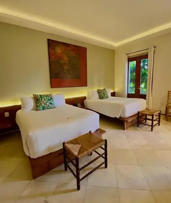 a large room with two beds and a window at Heritage Residences Signature Collection in Santo Domingo
