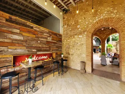 a restaurant with a stone wall and tables and chairs at Heritage Residences Signature Collection in Santo Domingo