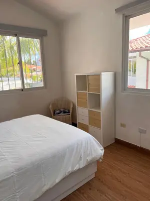 a bedroom with a bed and a dresser and two windows at EMY HOUSE in La Laguna