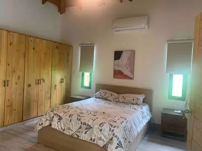 a bedroom with a large bed with wooden cabinets at Villa María Victoria, en Jarabacoa in Jarabacoa