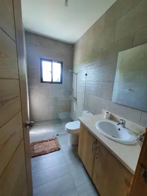 a bathroom with a sink and a toilet and a window at Villa María Victoria, en Jarabacoa in Jarabacoa