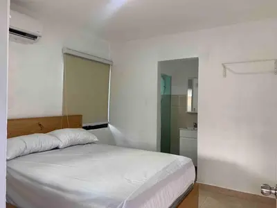 a bedroom with a white bed and a bathroom at Villa María Victoria, en Jarabacoa in Jarabacoa