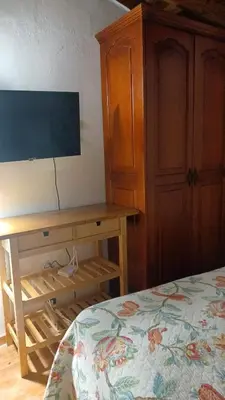 a bedroom with a bed and a wooden desk at Doña Mayra Aparta Hotel, Rustico in Las Terrenas