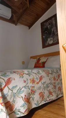 a bedroom with a bed with a colorful comforter at Doña Mayra Aparta Hotel, Rustico in Las Terrenas