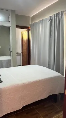 a bedroom with a bed with white sheets and a window at Hotel Vista al Morro in San Fernando de Monte Cristi
