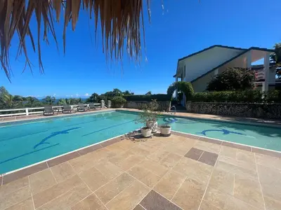 a swimming pool in front of a house at Catalina, Cabrera Oceanview Multi 2 BD 2 Bath Condo Units with Balcony and Pool in Caño Seco