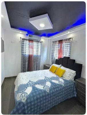 a bedroom with a bed with blue lights on it at JC Caribe Aparta Hotel #1 in La Caleta