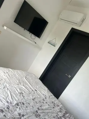 a bedroom with a bed and a flat screen tv at Perfecto para 3 personas. in Boca Chica