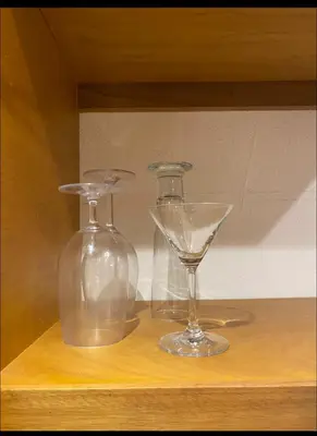 two glassases sitting on top of a wooden shelf at Estudio privado con vigilancia 24/7 con entrada independiente, in Santiago de los Caballeros