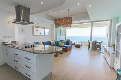 a kitchen and living room with a view of the ocean at Marbella Juan Dolio Beachfront in Juan Dolio