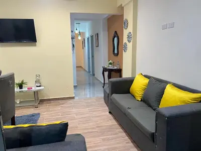 a living room with a couch and yellow pillows at HABITACIONES CON VISTA a LA BAHIA LA FAMILIA in Santa Bárbara de Samaná