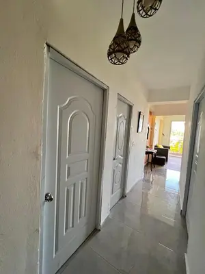 a hallway with a white door and a living room at HABITACIONES CON VISTA a LA BAHIA LA FAMILIA in Santa Bárbara de Samaná