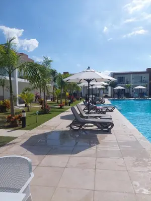 a group of lounge chairs and an umbrella next to a pool at Escapada en Boca chica in Boca Chica