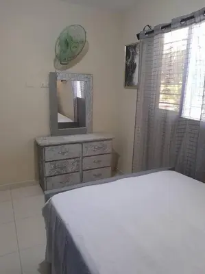 a bedroom with a dresser with a mirror and a dresser with a television at SDQ Apartamento Marbella 3 in La Ureña