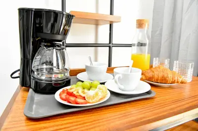 a counter with a coffee maker and plates of fruit at Honky Tonk Punta Cana in Punta Cana