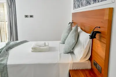 a bedroom with a bed with a wooden headboard at Honky Tonk Punta Cana in Punta Cana