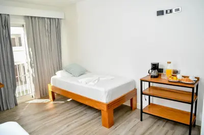 a bedroom with a bed and a nightstand with a table at Honky Tonk Punta Cana in Punta Cana