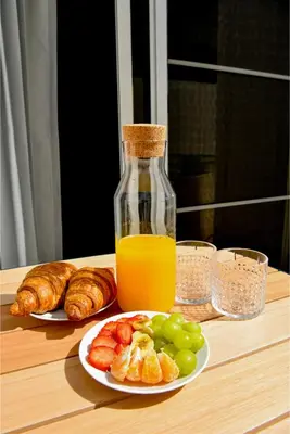 a table with a bottle of orange juice and a plate of fruit at Honky Tonk Punta Cana in Punta Cana
