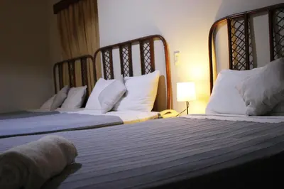 two beds in a hotel room with white pillows at Hotel Plaza Kavia in Santo Domingo