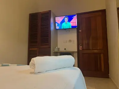 a bedroom with a bed with a tv on the wall at Hotel Plaza Kavia in Santo Domingo