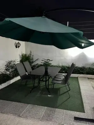 a table and chairs under a green umbrella at Villa Familiar con Piscina cerca Av Ecológica in La Ureña
