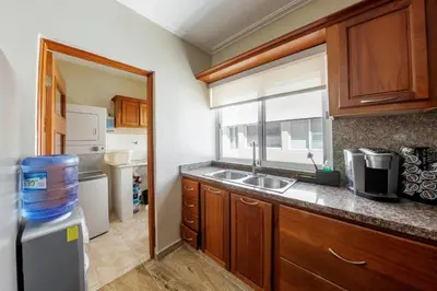 a kitchen with wooden cabinets and a sink and a window at Corte Sea A302, Luxury Penthouse in Punta Cana
